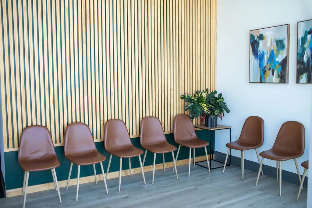 The Fortify Physical Therapy waiting room with wood slat wall, teal wainscot and leather chairs